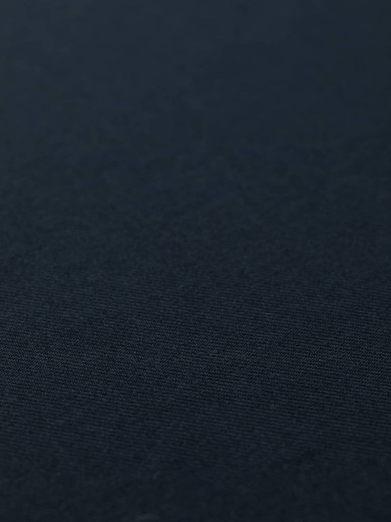 Angled flat lay of Seriously Navy serge fabric, displaying its rich navy colour, classic twill diagonals, and smooth yet resilient surface. The medium-weight wool blend offers warmth, strength, and refined sophistication.