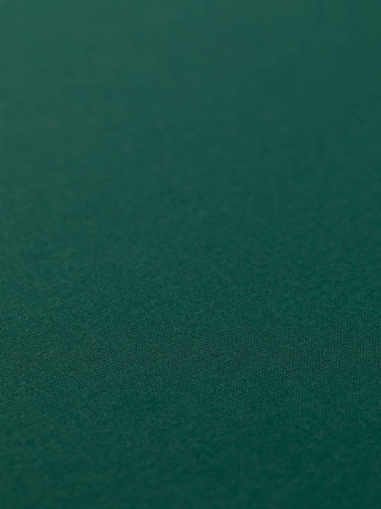 Flat angled view of Heritage Green wool-blend fabric, highlighting its deep, versatile racing green tone, close twill weave, and refined, cool-to-the-touch finish.