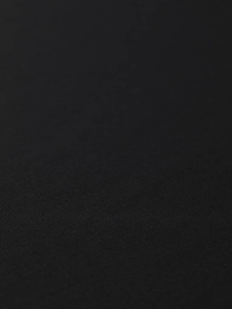 Flat angled view of Black Obsidian wool-blend, highlighting its deep black tone, classic twill structure, and even, smooth surface texture.