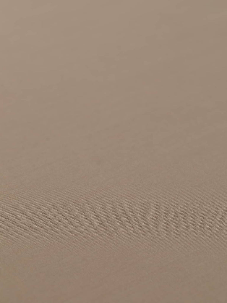 Flat angled view of Mocha Mousse superfine wool-blend worsted fabric, highlighting its warm beige-taupe color, crisp fine twill texture, and elegant, weighty drape suitable for structured silhouettes.