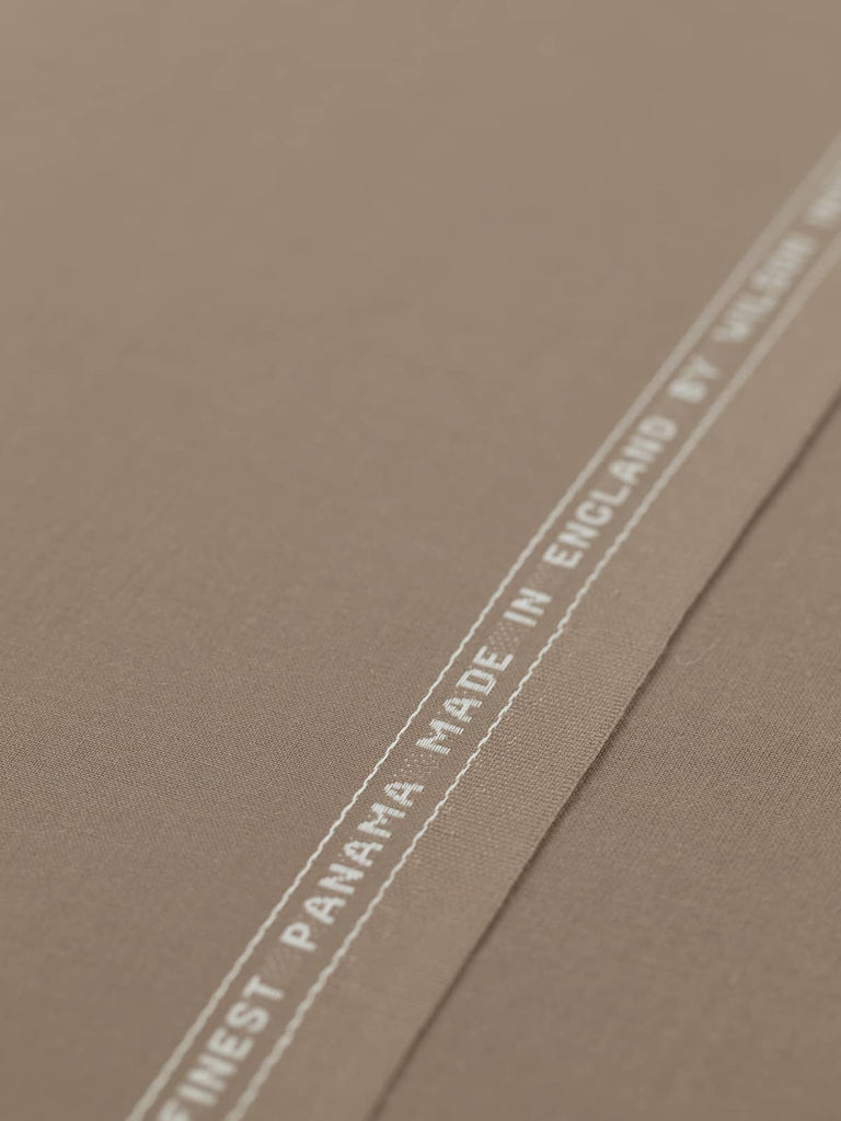 Flat angled view of Mocha Mousse superfine wool-blend worsted fabric, highlighting its warm beige-taupe color, crisp fine twill texture, and elegant, weighty drape suitable for structured silhouettes.