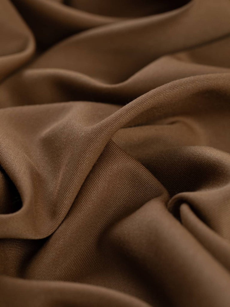 Close-up twist of Classic Tan wool-blend gabardine, showing its soft drape, warm tan hue, and fine twill weave with understated lustrous finish.