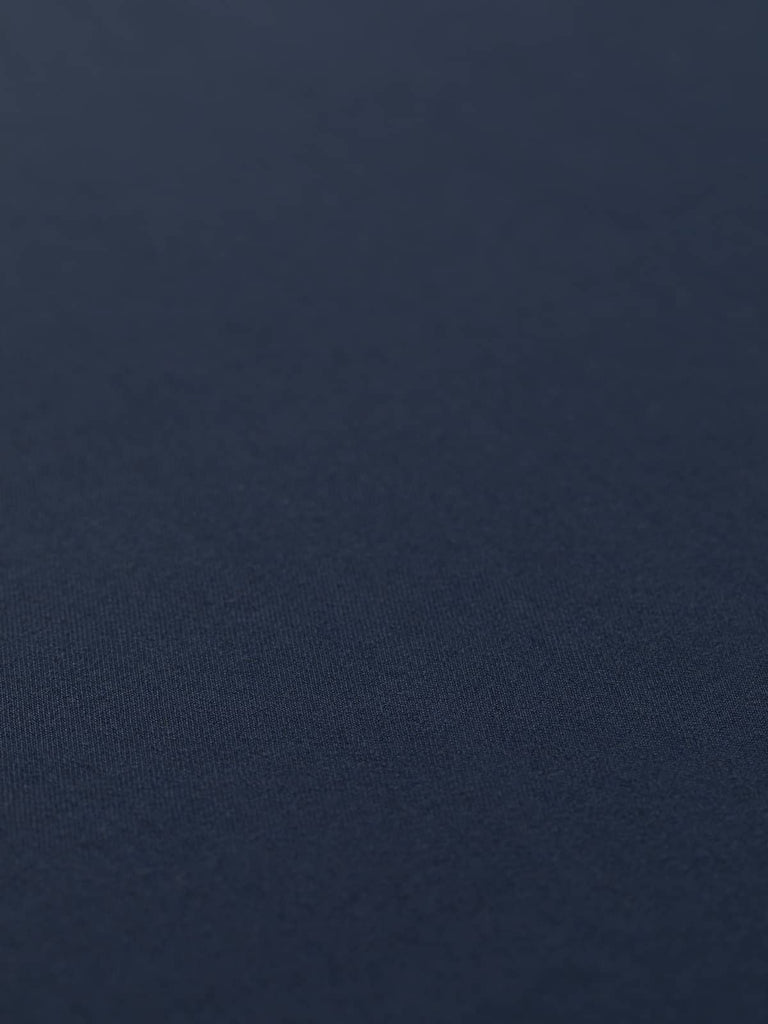 Flat angled view of Sapphire Smoke wool-blend twill, highlighting its cool worsted texture, crease-resistant quality, and versatile smoky navy tone.
