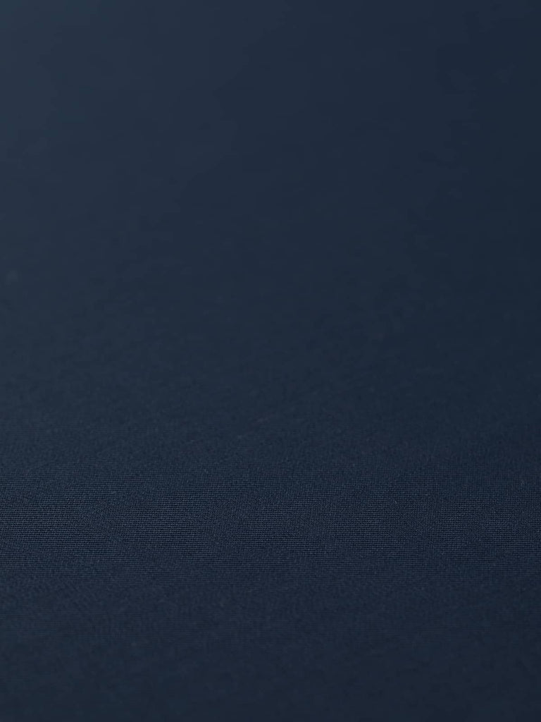 Flat angled view of Twilight Navy wool-blend twill, highlighting its refined worsted finish, crease resistance, and timeless deep blue tone.