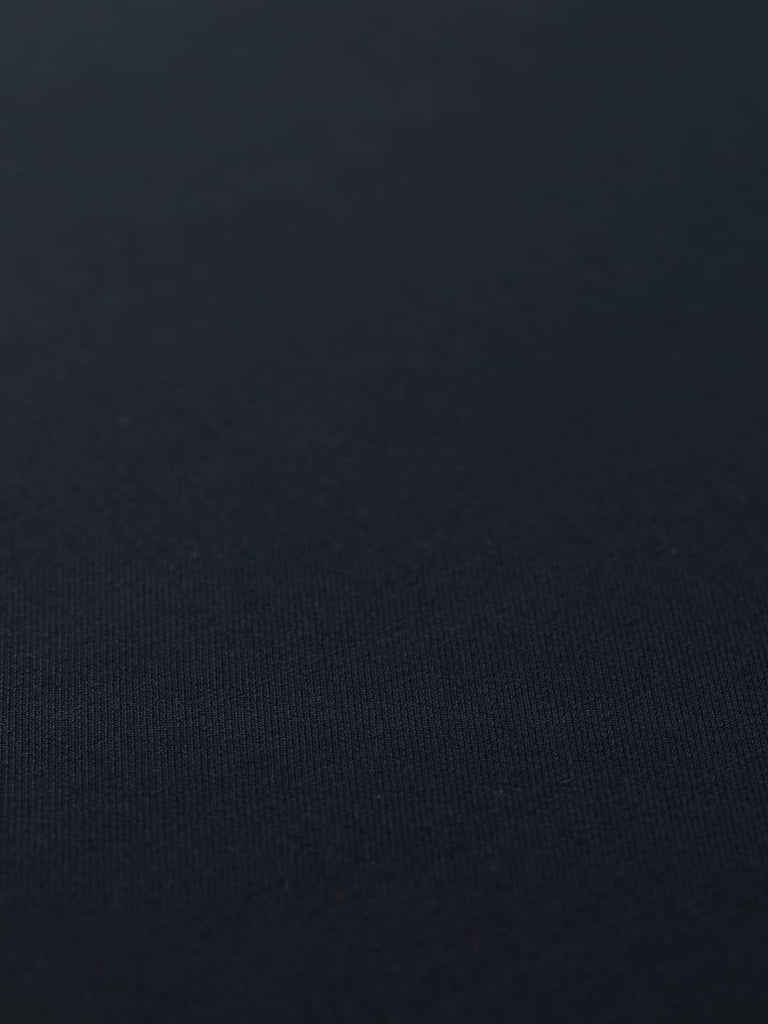 Flat angled view of Urban Midnight wool-blend twill, highlighting its sleek near-black navy tone, refined surface, and fluid yet structured drape