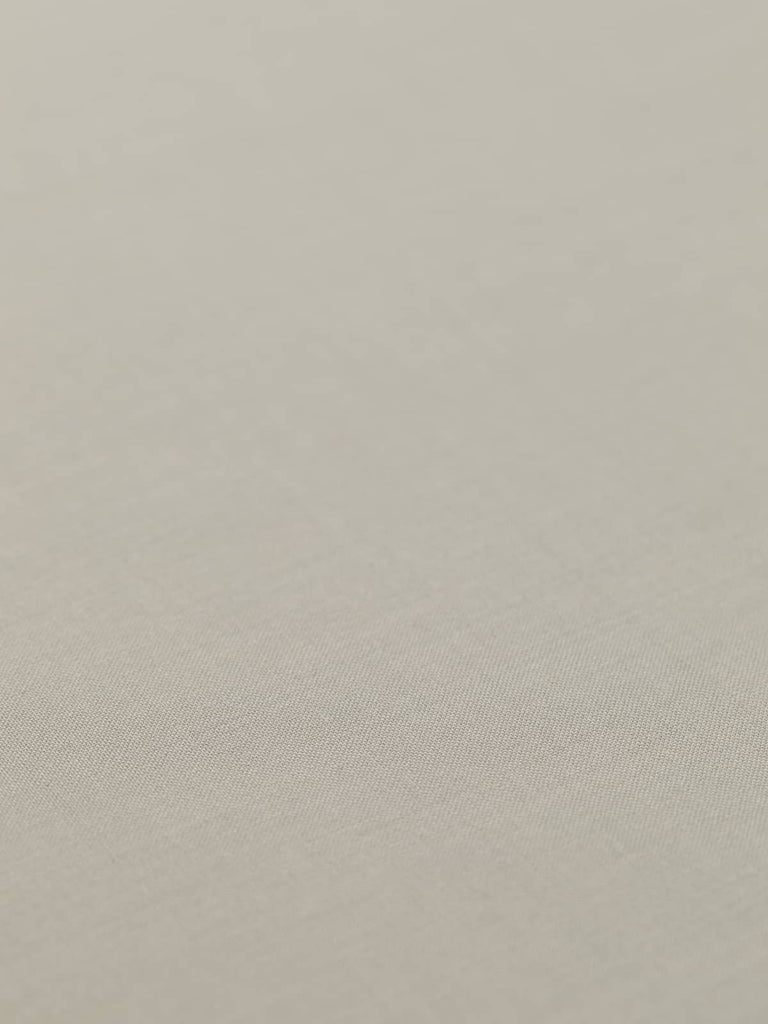 Flat angled view of Chino Beige wool-blend gabardine fabric, highlighting its light sandy beige color, crisp fine twill texture, and elegant weighty drape suitable for structured or fluid silhouettes.
