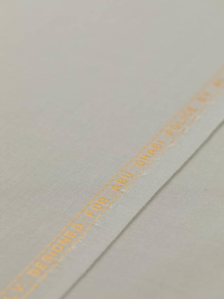 Flat angled view of Chino Beige wool-blend gabardine fabric, highlighting its light sandy beige color, crisp fine twill texture, and elegant weighty drape suitable for structured or fluid silhouettes.