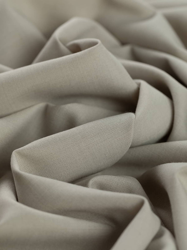 Close-up twist of Chino Beige wool-blend gabardine, showing even fine twill weave, soft brushed texture, and versatile light sandy beige tone ideal for tailored garments.