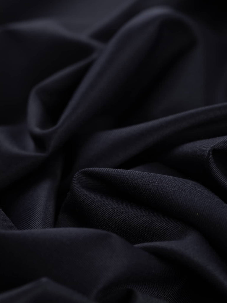 Close-up twist of Inkstone Navy wool-blend gabardine, showing refined fine twill weave, soft brushed feel, and rich dark navy tone with understated sophistication.
