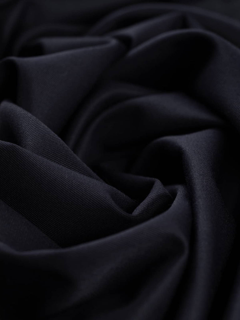 Close-up twist of Inkstone Navy wool-blend gabardine, showing refined fine twill weave, soft brushed feel, and rich dark navy tone with understated sophistication.