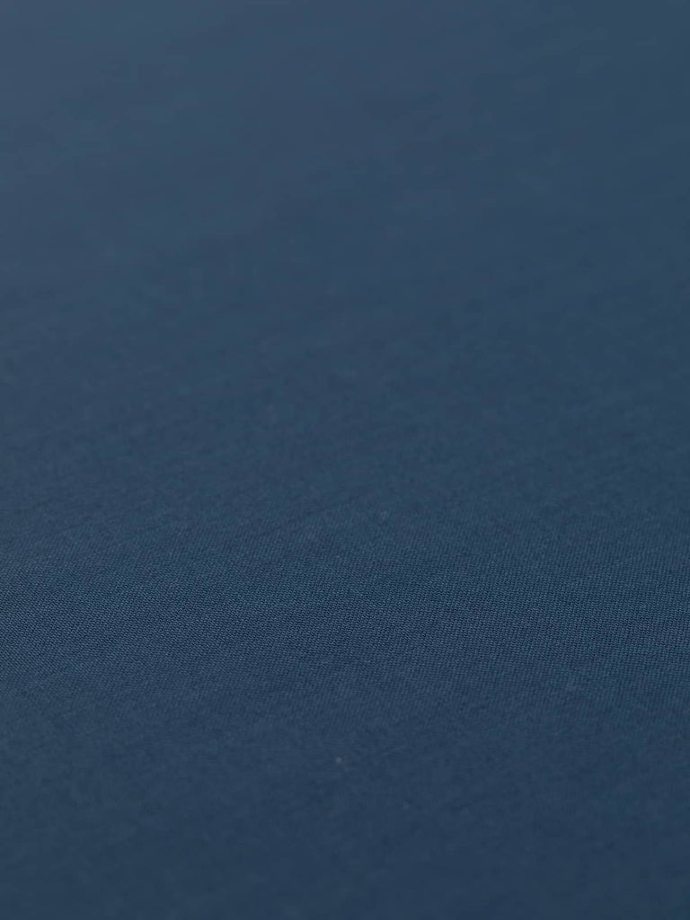 Flat angled view of Midnight Maritime wool-blend worsted fabric, highlighting its elegant French navy shade, crisp fine weave, and fluid drape for tailoring.