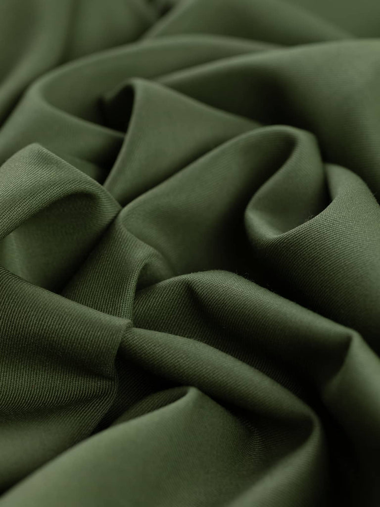 Twist of Guardsman’s Green wool-blend twill, showing soft handle, elegant drape, and heritage olive shade softened by organic undertones.