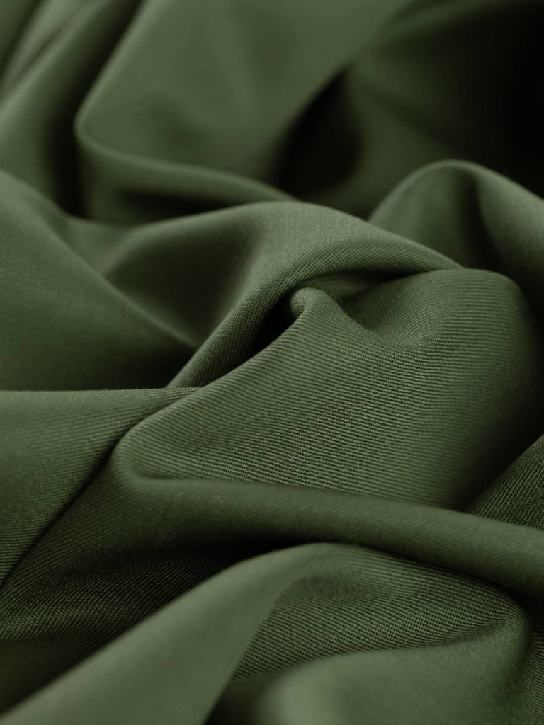 Twist of Guardsman’s Green wool-blend twill, showing soft handle, elegant drape, and heritage olive shade softened by organic undertones.