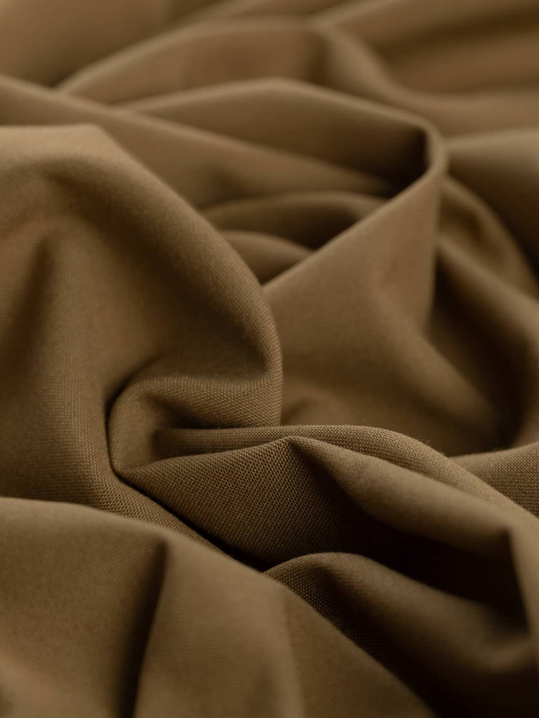 Twist of Golden Hazel wool-blend worsted fabric, showing soft cotton-like texture, smooth drape, and warm autumnal brown shade