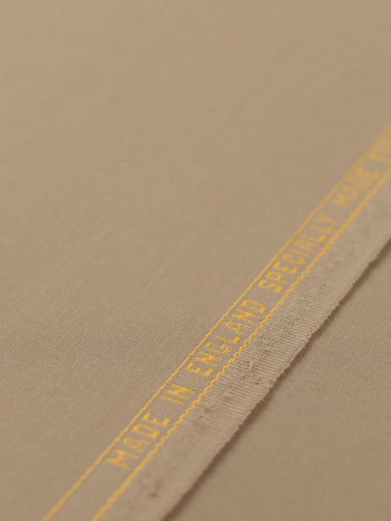 Flat angled view of Wheaten Gold wool twill fabric, highlighting fine weave, warm natural tone, and luxurious suiting quality