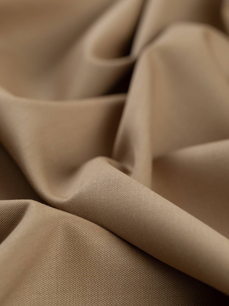 Twist of Wheaten Gold wool twill fabric, showing smooth worsted-like texture, refined sheen, and elegant soft drape in muted golden hue