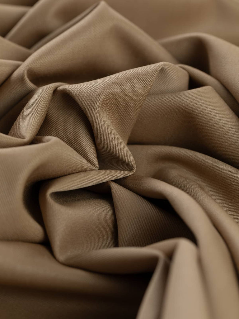 Twist of Wheaten Gold wool twill fabric, showing smooth worsted-like texture, refined sheen, and elegant soft drape in muted golden hue