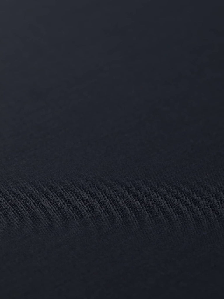 Flat angled view of Midnight Regent wool twill fabric, highlighting polished finish, classic solid hue, and luxurious midnight navy shade