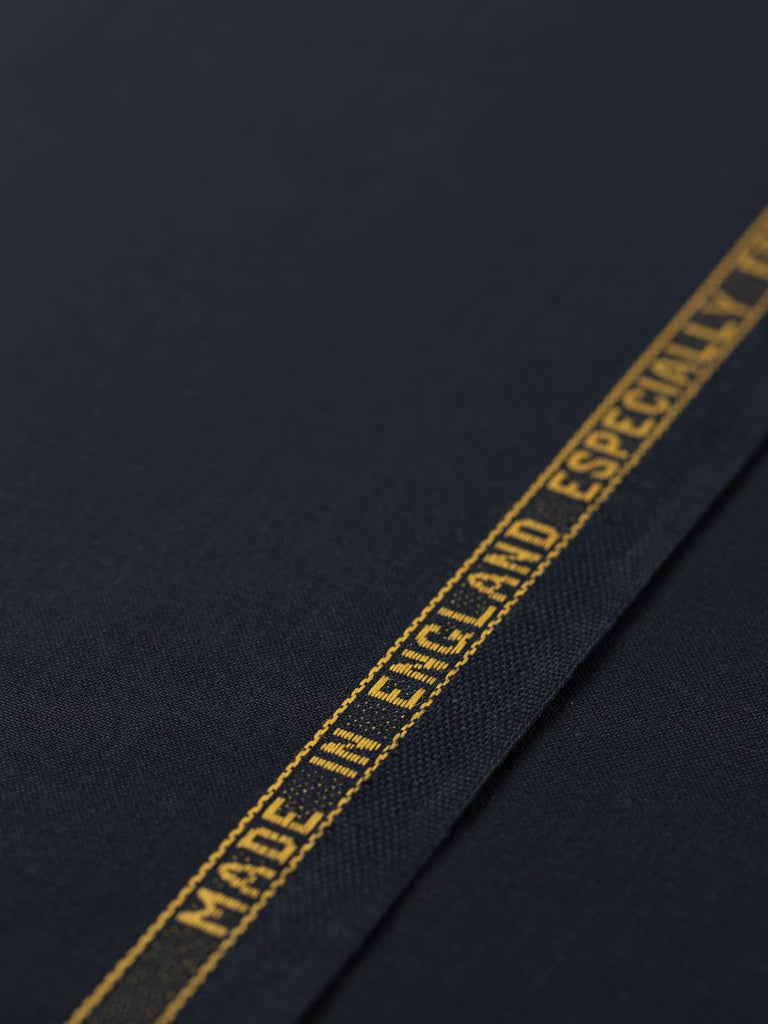 Flat angled view of Midnight Regent wool twill fabric, highlighting polished finish, classic solid hue, and luxurious midnight navy shade