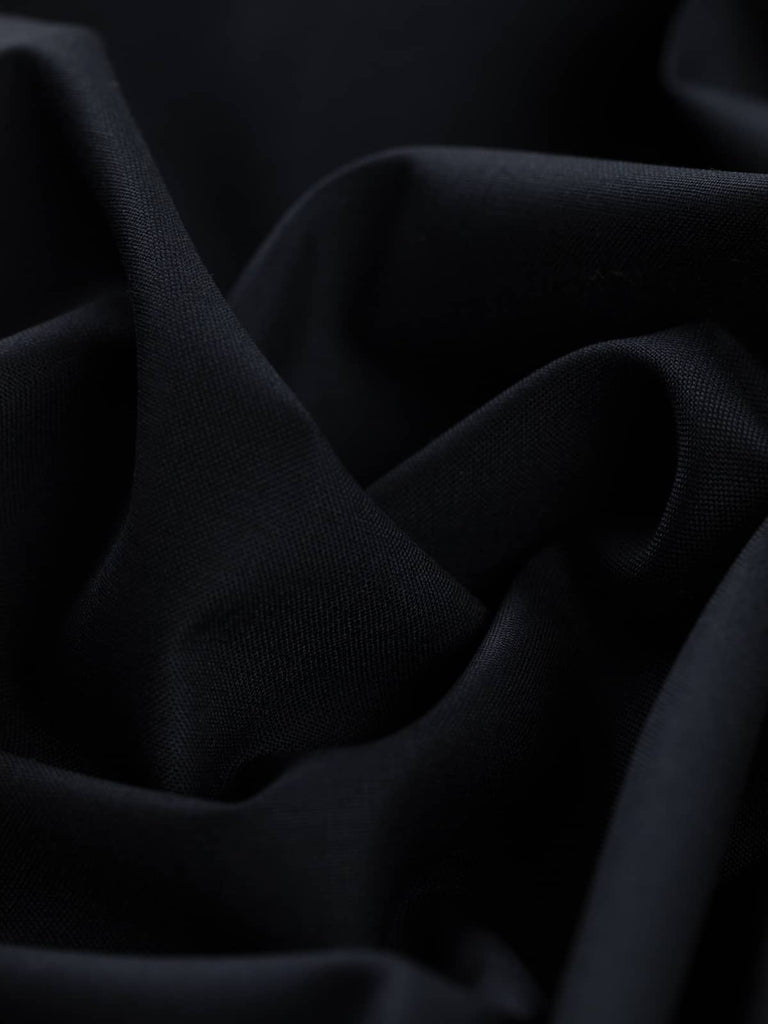 Twist of Midnight Regent wool gabardine twill fabric, showing smooth fine texture, soft drape, and deep formal midnight blue tone
