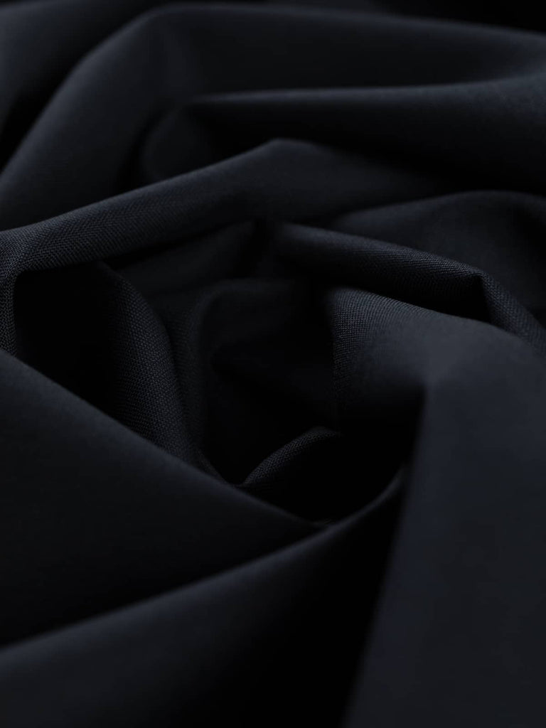 Twist of Midnight Regent wool gabardine twill fabric, showing smooth fine texture, soft drape, and deep formal midnight blue tone