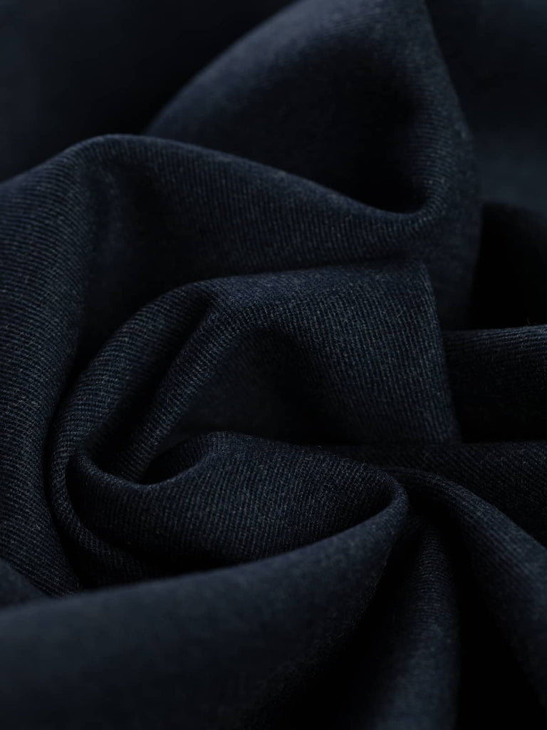 Twist of Deep Abyss wool gabardine fabric, showing soft brushed wool texture, fluid drape, and deep ocean-inspired navy tone