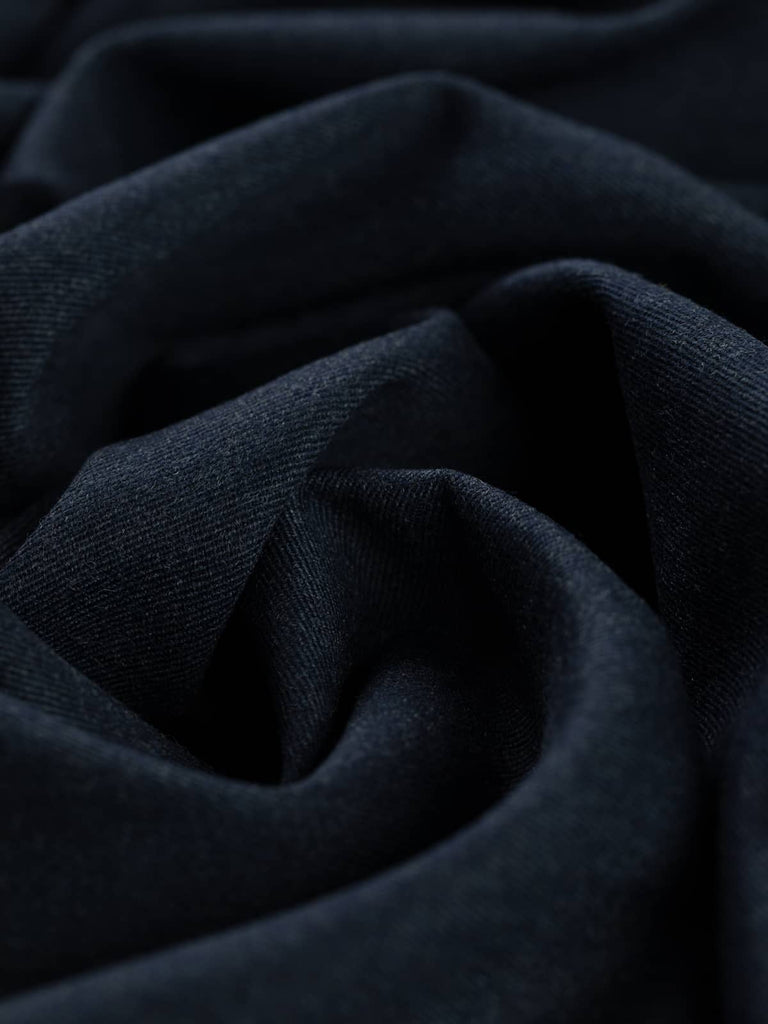 Twist of Deep Abyss wool gabardine fabric, showing soft brushed wool texture, fluid drape, and deep ocean-inspired navy tone