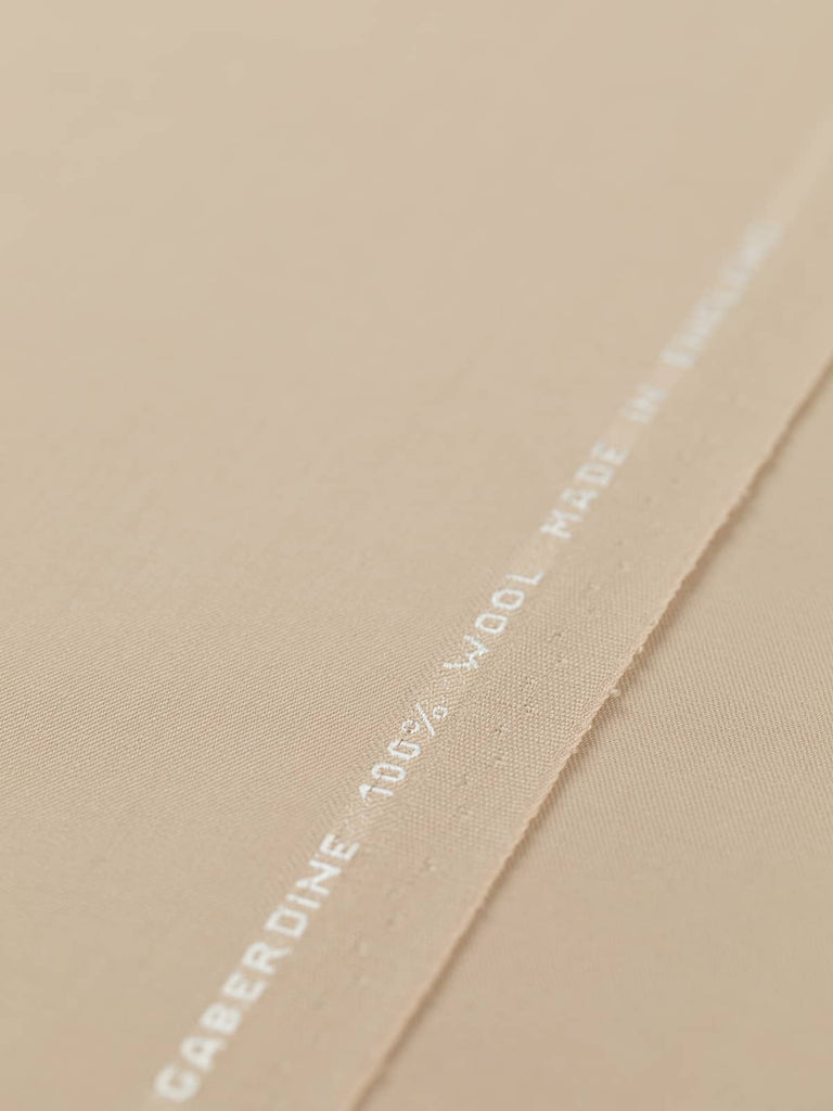 Flat angled view of Blushed Oat wool fabric, highlighting fine twill weave, silky surface, and gentle blush-beige shade