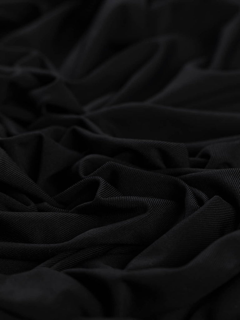 A silky black jersey fabric with a soft, slinky drape and subtle sheen. The fine knit construction creates a delicate, lightweight texture, perfect for fluid and elegant designs.