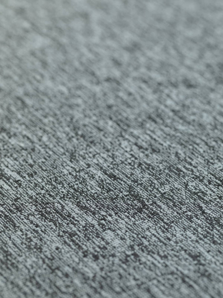 A flat view of the Marled Hacci Sweater Knit in Ashes, displaying its classic stocking stitch and lightweight, drapey texture. The mid-grey and black marled tones are ideal for layering pieces, complementing casual wardrobes effortlessly.