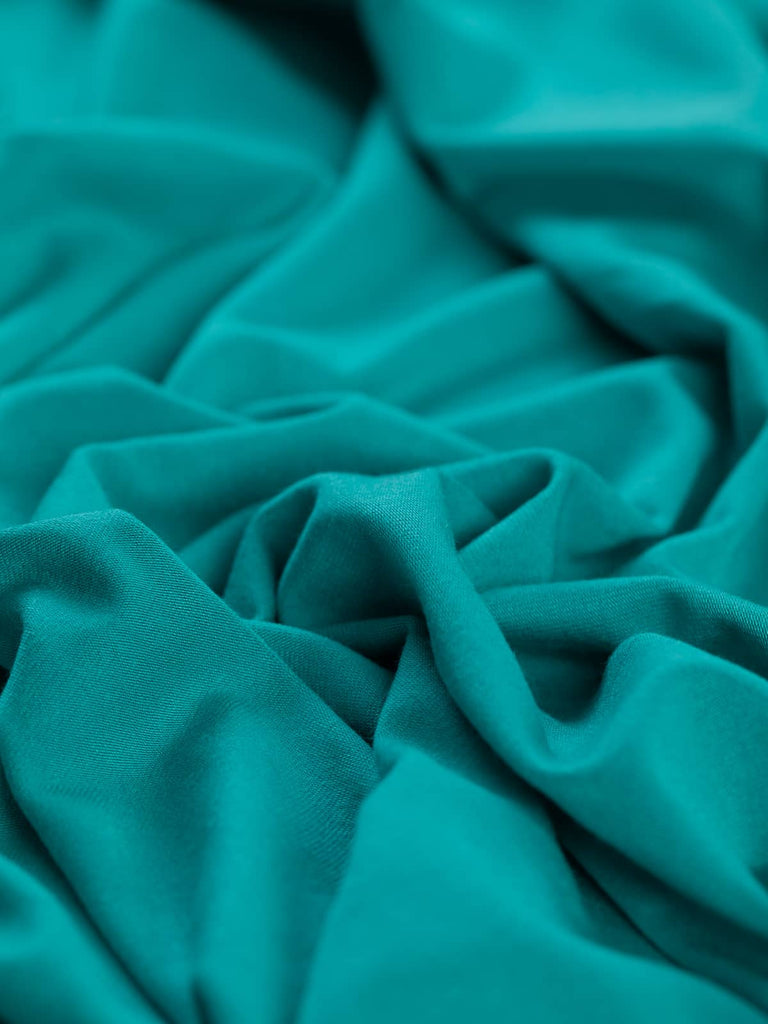 Angled twist photo of a turquoise viscose single jersey