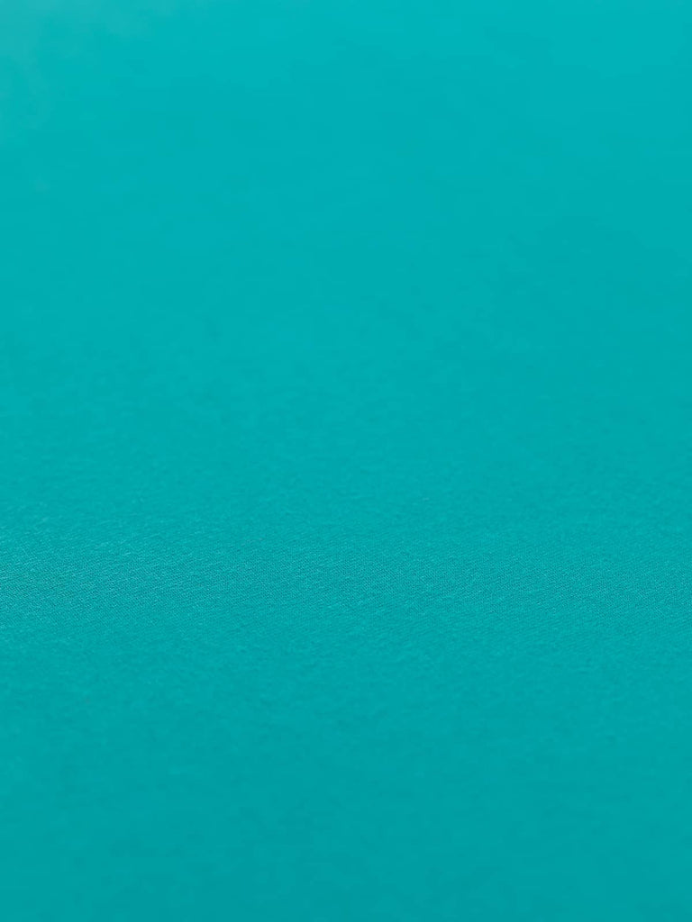 This is a flat angled shot of a plain turquoise viscose jersey fabric
