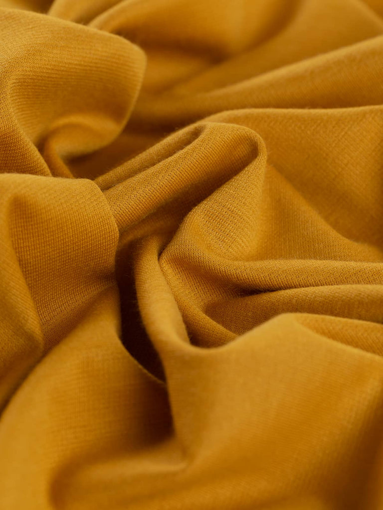 Golden Citrine Ponte de Roma glows with warm, sun-kissed hues, evoking golden sunflowers, honey, and rich summer light. This versatile jersey offers a fluid drape and excellent stretch, perfect for both casual and statement pieces.