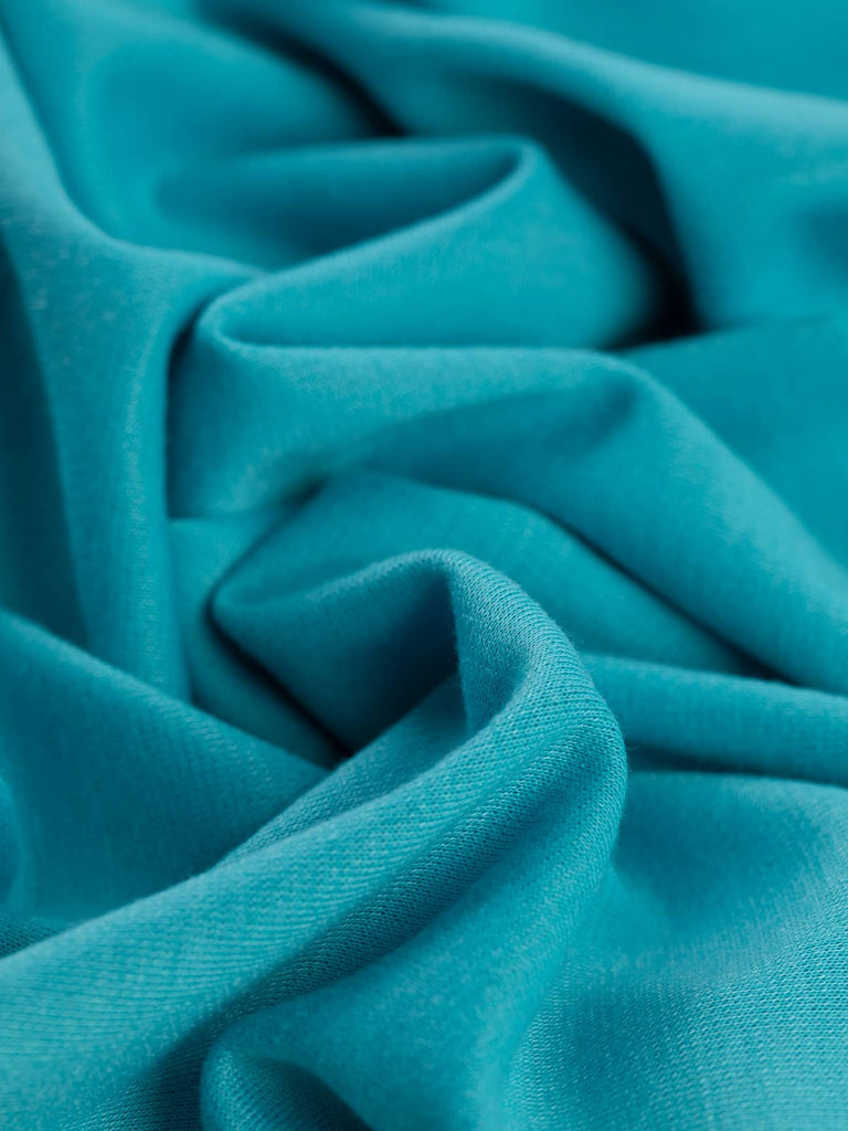 Nevada Turquoise Ponte de Roma radiates vibrant, uplifting hues inspired by tropical lagoons and cloudless summer skies. With a smooth drape and excellent stretch, this fabric is perfect for creating stylish and comfortable pieces.