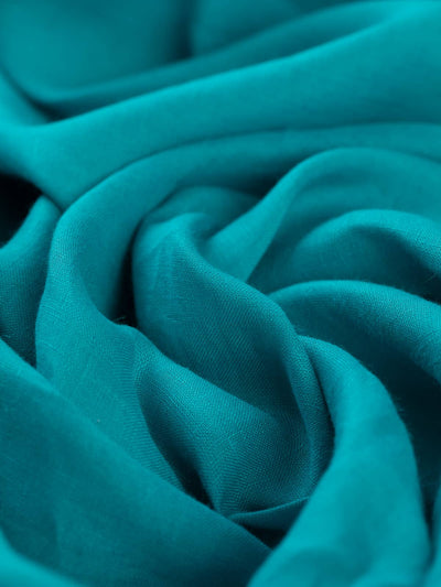 Turquoise lightweight linen fabric with fine slubs, plain weave, and airy shirt‑weight drape.