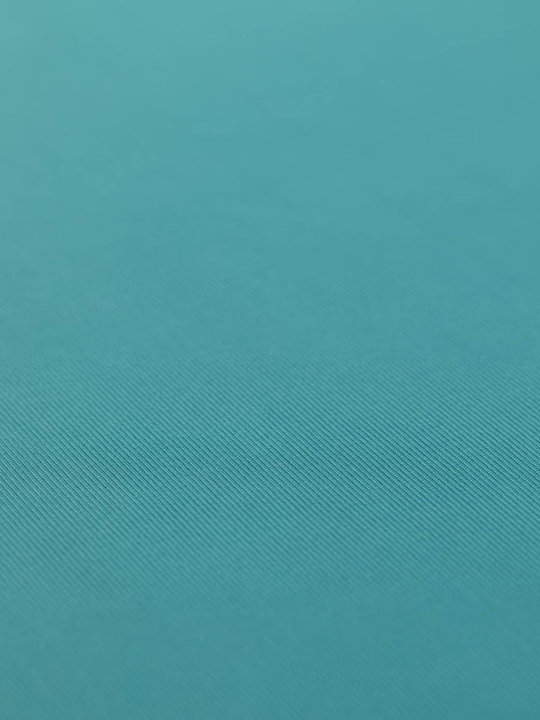 A flat view of the Silken Stretch Rib fabric in Turquoise Jade, displaying its smooth, medium-weight surface and elegant, subtle turquoise hue. The finely knitted pattern and silky finish are visible, illustrating the fabric's versatile and stylish properties.