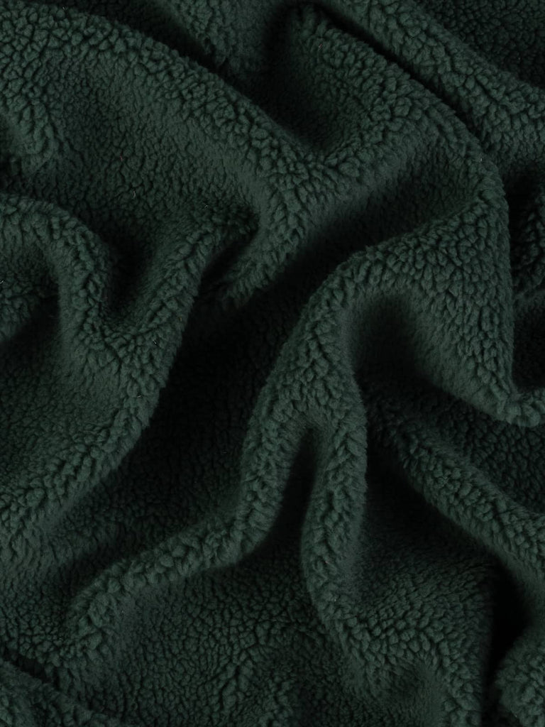 The fleece fabric twisted to highlight its dense, fluffy surface and stretch properties, emphasizing the luxurious and snug feel.