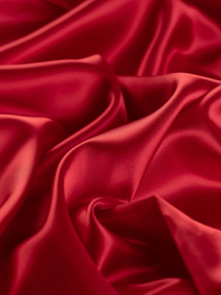Rich Cardinal Red satin fabric, 140cm wide, with a lustrous sheen, 100% acetate, lightweight and silky, ideal for high-quality tailoring and luxurious occasion wear