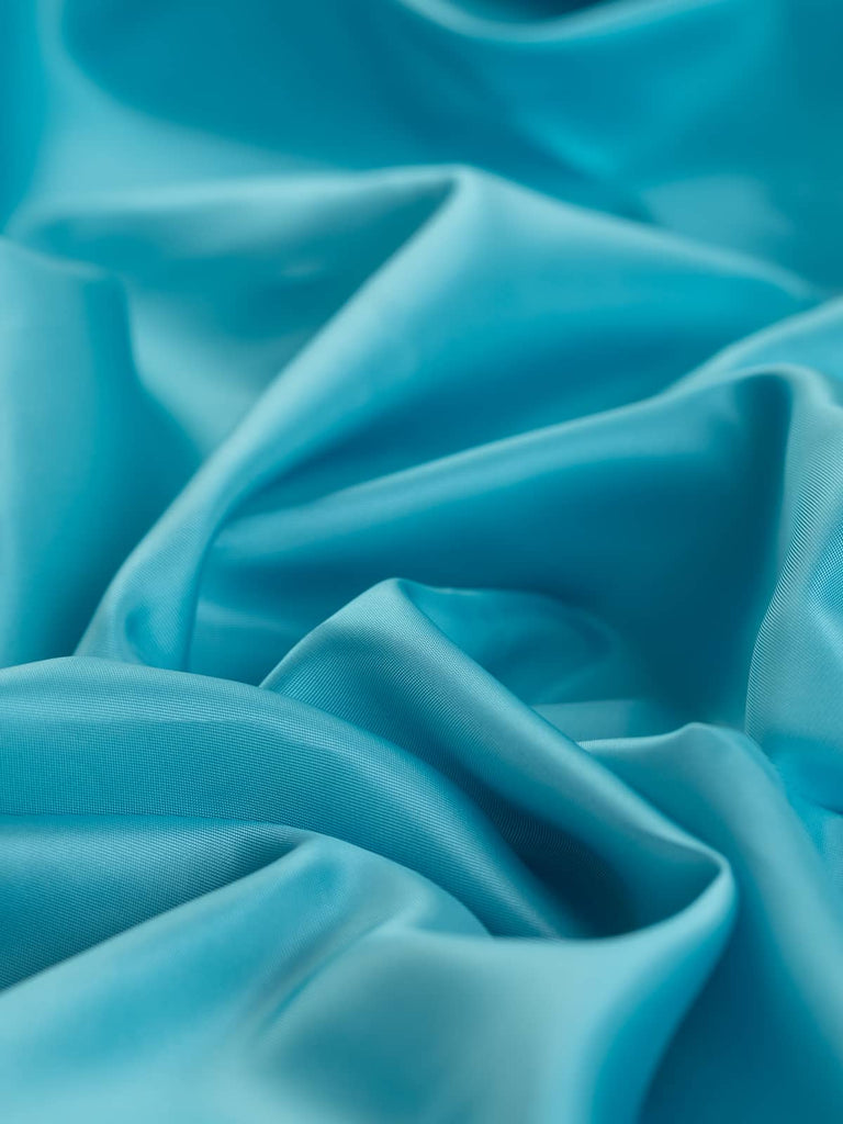 Very light pastel turquoise woven lining fabric, 150cm wide, in a superfine twill weave, 100% polyester, soft and silky with a satin-like sheen, perfect for classic tailoring and chic fashion pieces