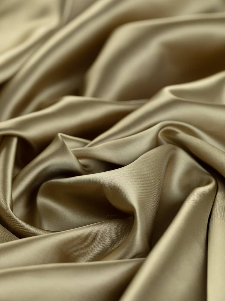Luxurious golden beige woven lining fabric, 140cm wide, in a solid fine satin weave, 100% acetate, light yet strong with a silky smooth texture, ideal for classic tailoring and elegant occasion wear