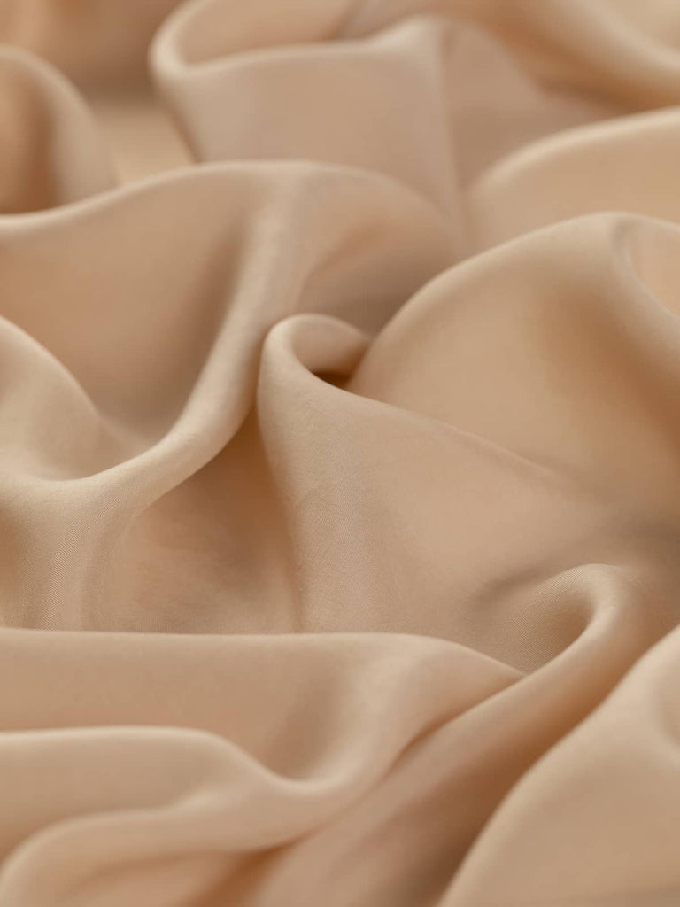 Very light cupro lining fabric, 130cm wide, in a solid superfine flat weave, 100% cupro composition, soft and silky with sweet nutty pink undertones, ideal for classic light tailoring and elegant occasion wear.