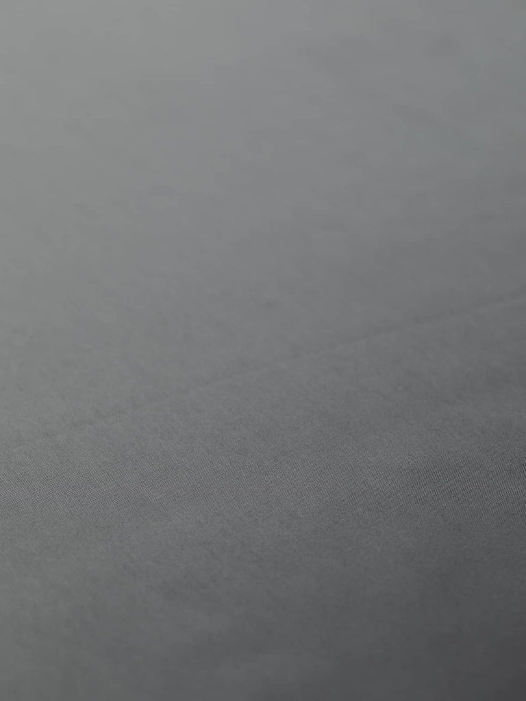 Elegant metallic dark grey satin fabric, 144cm wide, featuring subtle blue-titanium undertones and a lustrous, smooth finish, ideal for lining jackets, skirts, and dresses, as well as being suitable as a high-quality satin outer fabric.