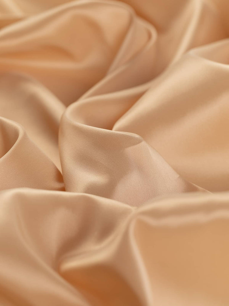 Champagne beige woven lining fabric, 140cm wide, with a pearl-like warm tone and a superfine solid flat weave. Made from 100% acetate, this very light fabric offers a silky, smooth, and semi-shiny satin-like finish, ideal for adding a soft, drapey feel to the linings of jackets, dresses, and fashion accessories.