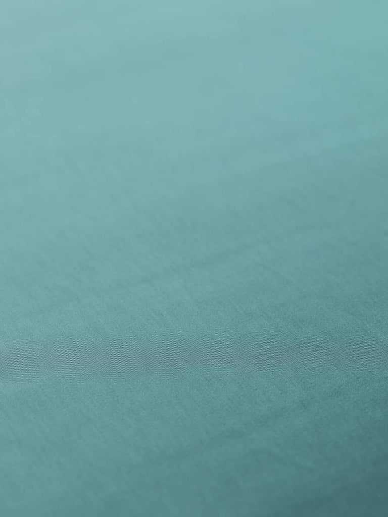 Viscose & Acetate satin lining fabric in Frosted Spruce, 140cm wide, with a fine satin weave. Perfect for classic tailoring and occasion wear, this light yet strong fabric features a silky, highly lustrous surface in a serene blue-green hue.