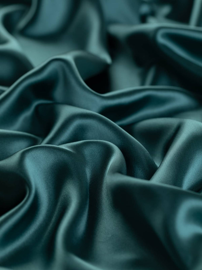 Frosted Spruce satin lining fabric in a subtle blue-green shade, 140cm wide. This viscose and acetate blend offers a silky, lustrous finish with a smooth, drapey feel, ideal for lining jackets, skirts, and dresses or as a quality outer fabric.