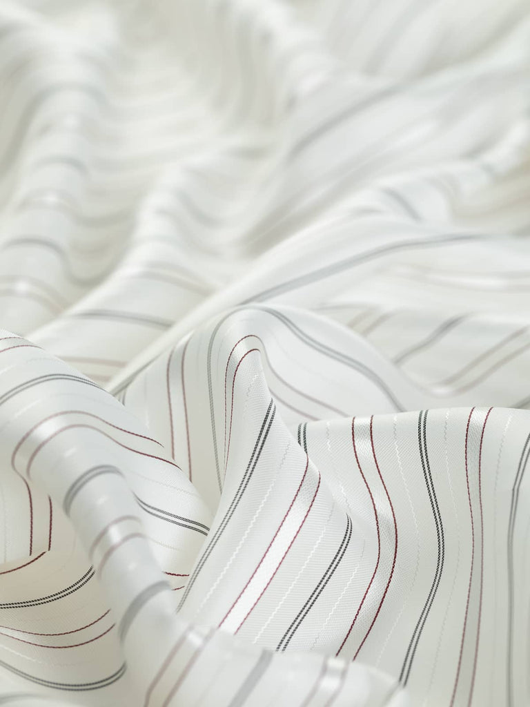 142cm wide Viscose & Acetate Stripe Lining fabric, featuring cool classic white with alternating black and ox blood red stripes. Ideal for jackets, skirts, and coats, this lightweight fabric offers a soft, silky feel and a semi-lustrous finish.