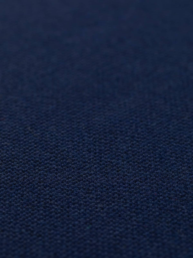 A flat angled view of Celestial Blue hopsack fabric, showcasing its dark, jewel-like navy hue. The fabric’s solid colour and heavy drape quality provide a luxurious yet versatile textile, ideal for creating a polished and serene environment.