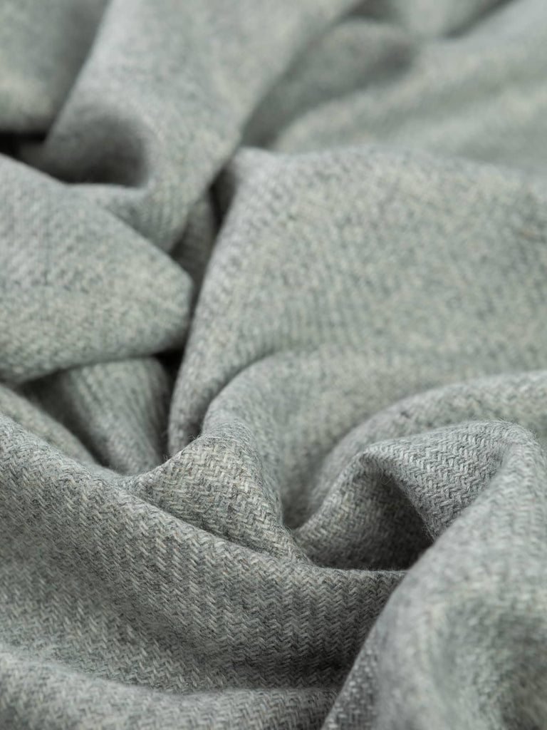 Twist of Fossil Sand Cashmere fabric showing reversible sides in fossil grey and sand beige, highlighting its luxurious sheen and fluid, snuggly drape.