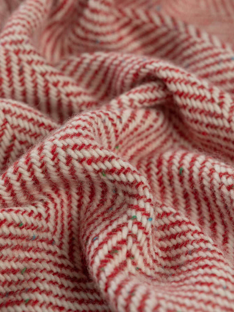 Twist of Festive Red Jumbo Herringbone showing soft brushed lambswool texture and colourful Donegal neps in red, white, and multitone flecks.