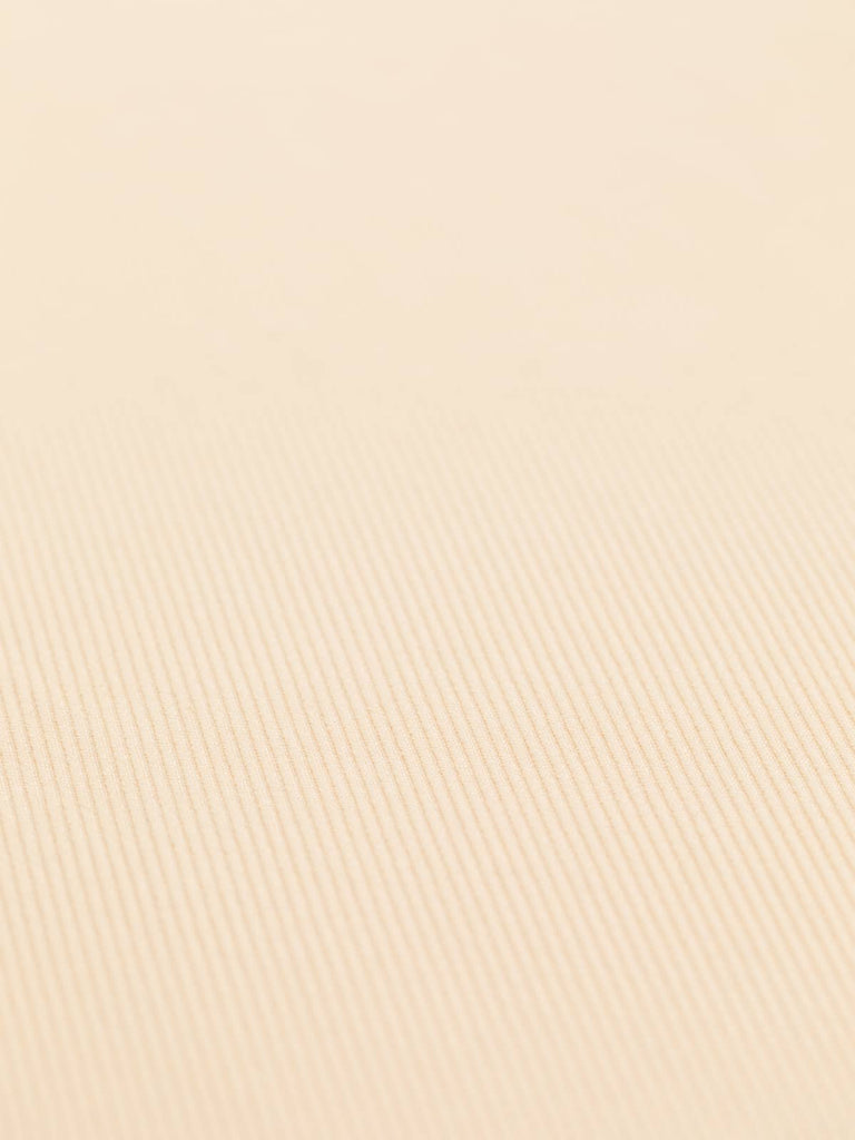 A flat view of the Raised Cotton Twill - Peach Sorbet, capturing the cooling pastel peach color that evokes a sense of calm and elegance. The clear display of the chunky twill weave underscores the fabric's stability and lightly textured surface. With a width of 152.4cm, this versatile fabric is ideal for creating a range of garments, from blazers, cigarette style pants, and skirts to shift dresses and pinafores.